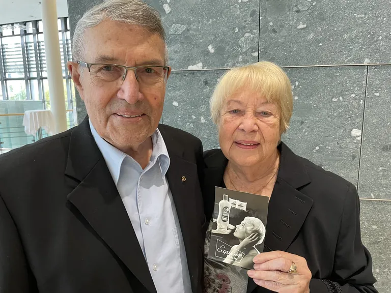 Ehepaar Riesebeck mit Werbeplakat