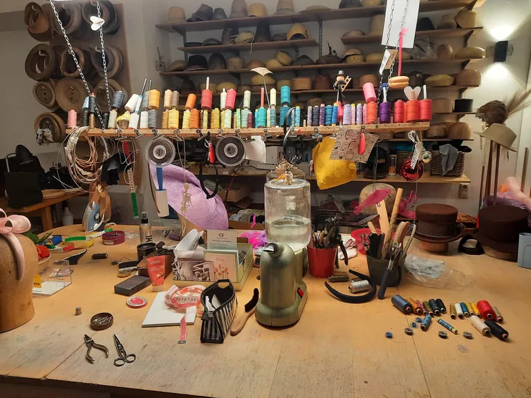 Arbeitstisch mit allerei Werkzeugen und N&auml;hgarn-Spulen