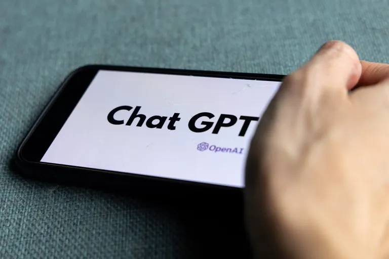 Frauenhand h&auml;lt Smartphone mit Logo ChatGPT