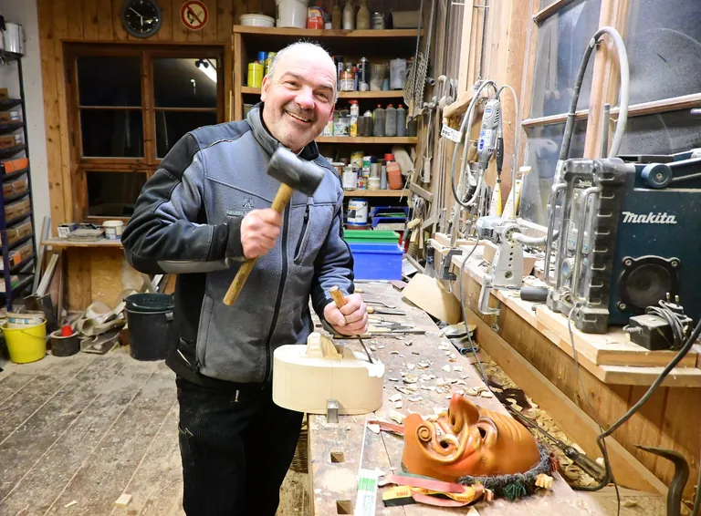 Zimmermeister Albrecht schnitzt Maske in seiner Werkstatt