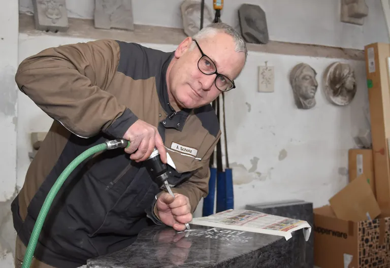 Steinmetz Arnd Scholz bearbeitet Grabstein