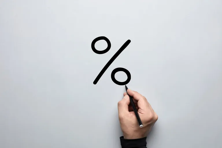 M&auml;nnliche Hand malt Prozentzeichen auf graue Fl&auml;che.