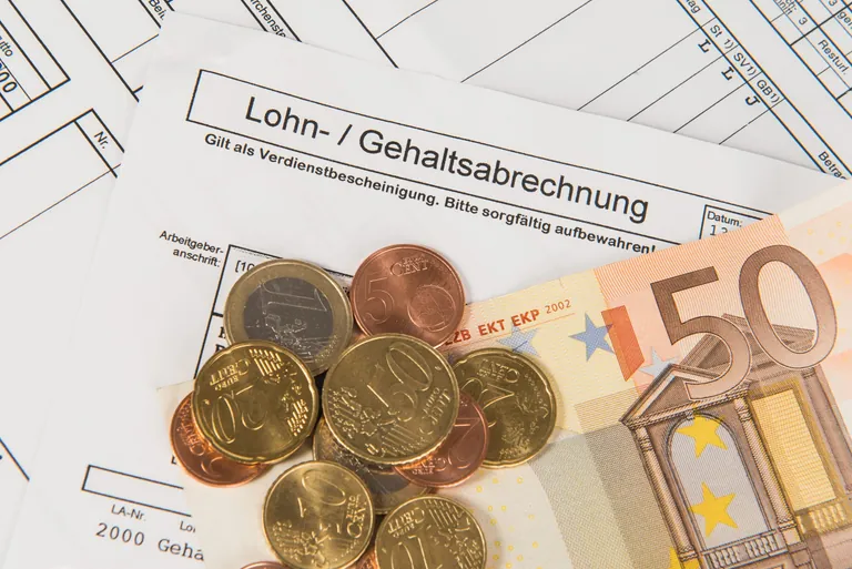 Lohnabrechnung mit Geldscheinen und -m&uuml;nzen.