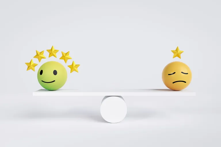 Gl&uuml;ckliches und trauriges Emoji auf Waage.