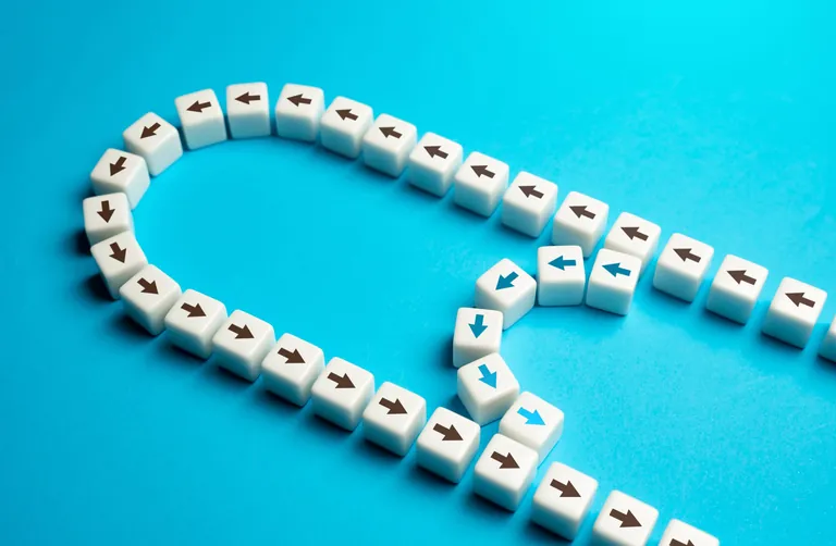 Pfeile auf Baukl&ouml;tzen auf blauem Hintergrund. Symbolbild "Verk&uuml;rzung".