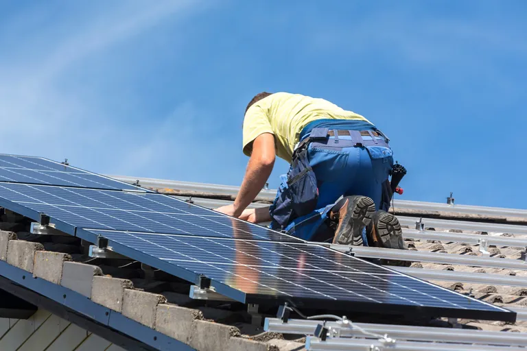 Dachdecker installiert Solaranlage.