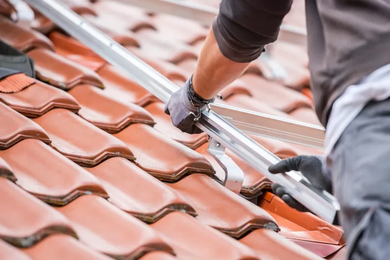 Solarausbau: Handwerker installiert Halterungen f&uuml;r eine Solaranlage