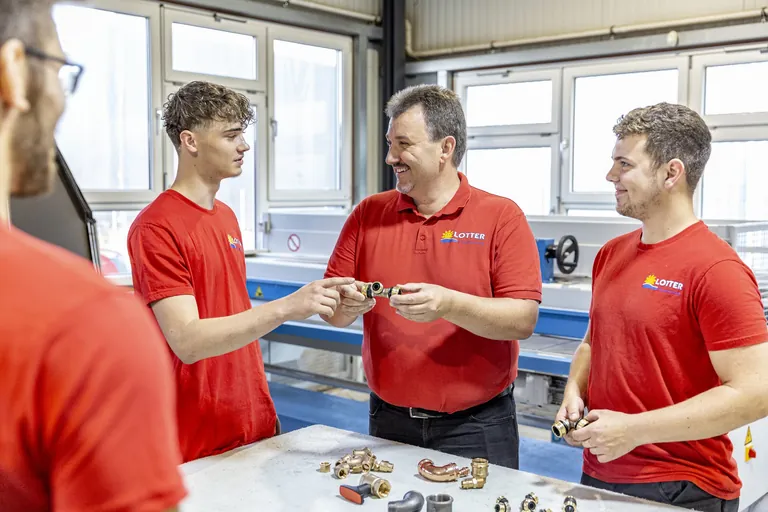Installateur- und Heizungsbaumeister Andreas Lotter spricht mit seinen drei Auszubildenden.