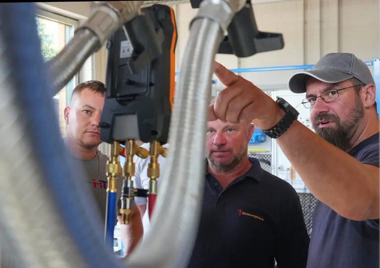Meistersch&uuml;ler Martin Scholz (r) unterh&auml;lt sich mit Kollegen im W&auml;rmepumpen-Labor im Bildungs- und Innovationscampus der Handwerkskammer Potsdam (BIH).