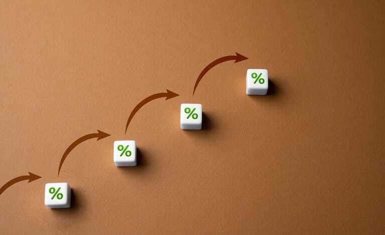 Bausteine mit Prozentzeichen und Pfeilen auf braunem Hintergrund.