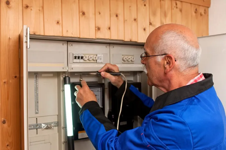 &Auml;lterer Elektriker bei der Arbeit.