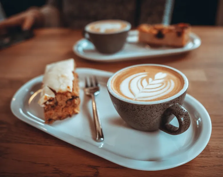 Kaffee und Kuchen auf Tablett.