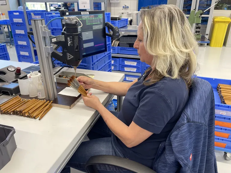 Nadja Cassim montiert Kosmetikpinsel auf Holzstiele