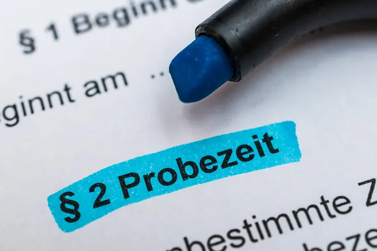 Wort "Probezeit" blau markiert in Arbeitsvertrag.
