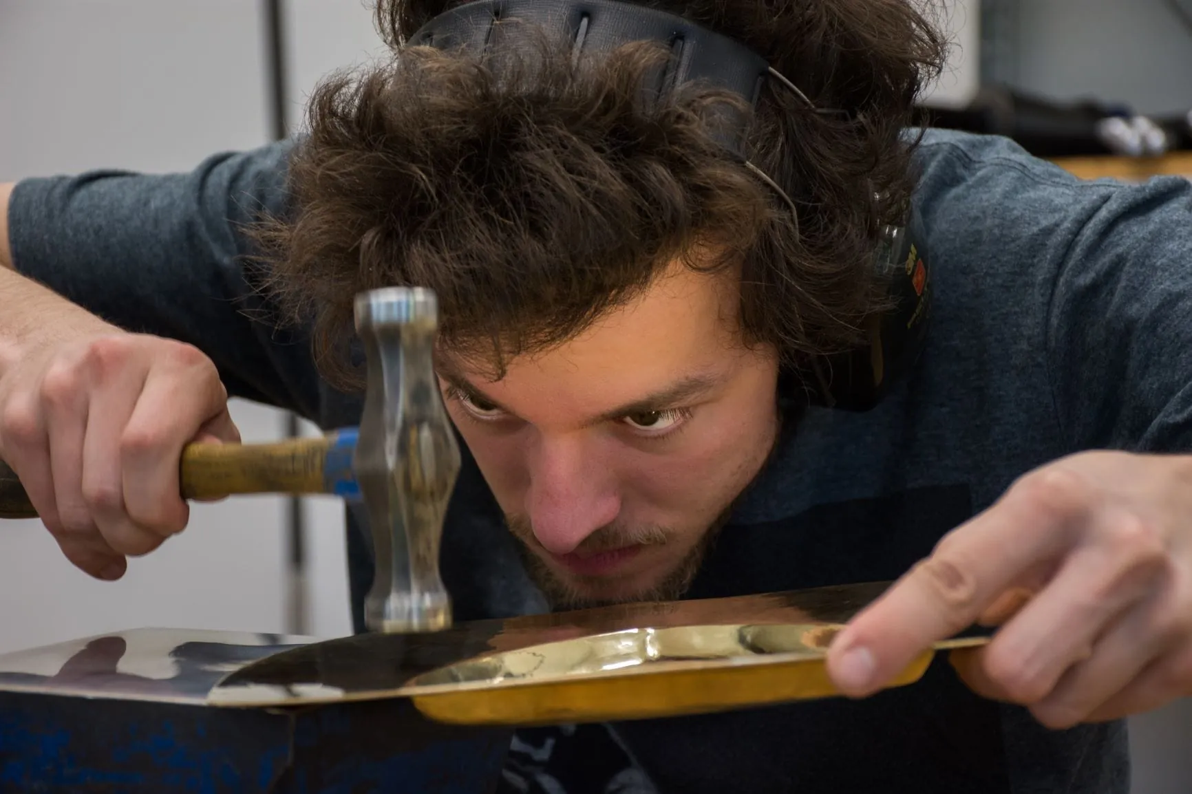 Angehender Silberschmied beim Planieren eines Tabletts