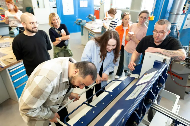 Angehende Lehrerinnen und Lehrer probieren sich an der Blechbiegemaschine im Berufsbildungs- und Technologiezentrum der Handwerkskammer f&uuml;r Schwaben.