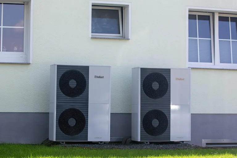 Zwei W&auml;rmepumpen stehen vor einem Mehrfamilienhaus in K&ouml;ln.
