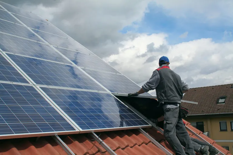 Handwerker installiert Solaranlage auf Dach.
