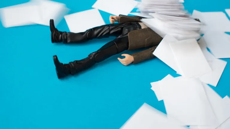 Figur in Anzug von Papier &uuml;bersch&uuml;ttet. Symbolbild B&uuml;rokratie.