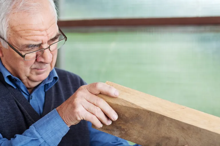 Senior-Chef pr&uuml;ft Holz