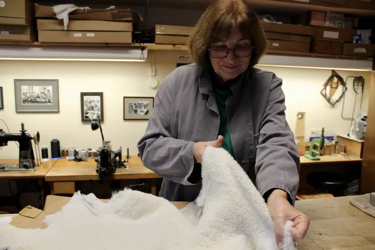 Handschuhmachermeisterin Gerlinde Ballin-Huth prüft sorgfältig die Zugrichtung eines Lammfells – ein entscheidender Schritt, um perfekte Passform und Flexibilität zu gewährleisten.