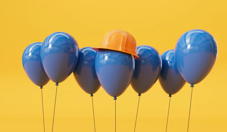 Blaue Ballons mit orangem Helm