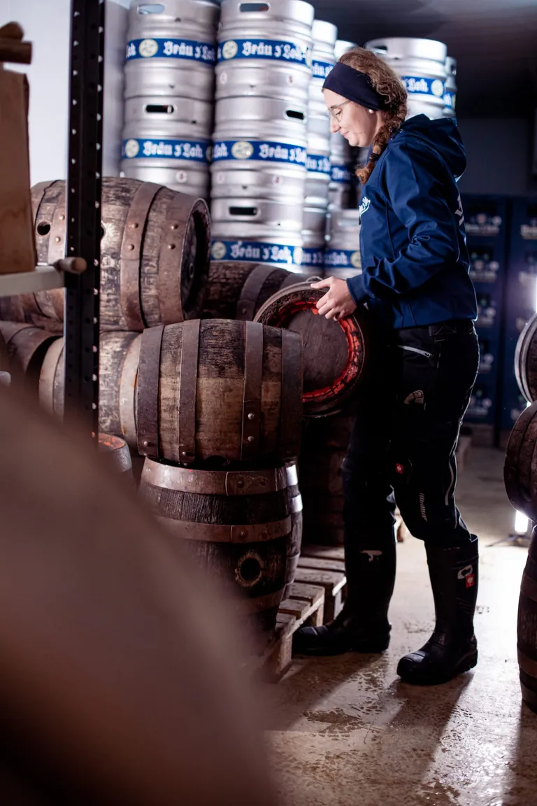 Junge Auszubildende tr&auml;gt Bierfass