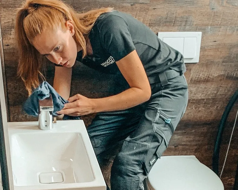 Sandra Hunke an einer Waschbecken-Armatur.