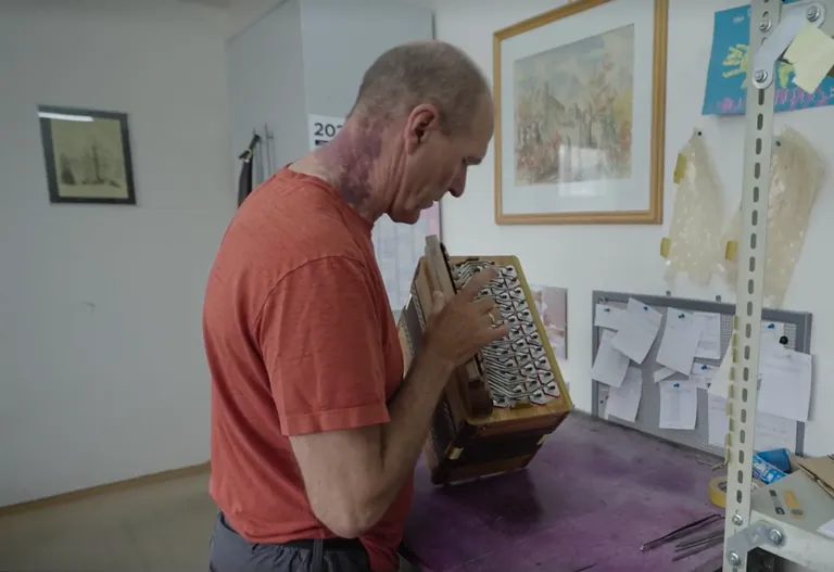 Mann stimmt Harmonika