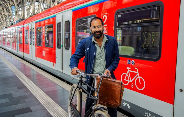 Mann mit Fahrrad auf dem Bahnsteig