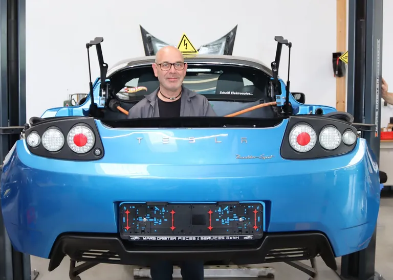 Conrad Buck steht in der Karosserie eines Tesla Roadster