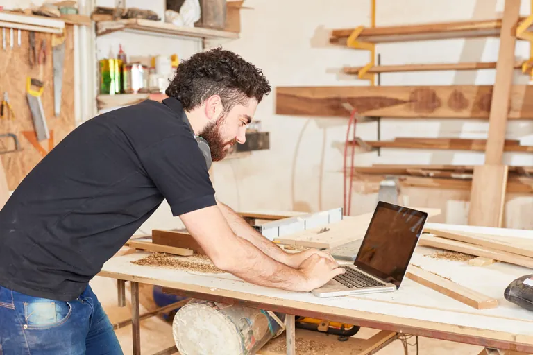 Junger Handwerker am Laptop Computer