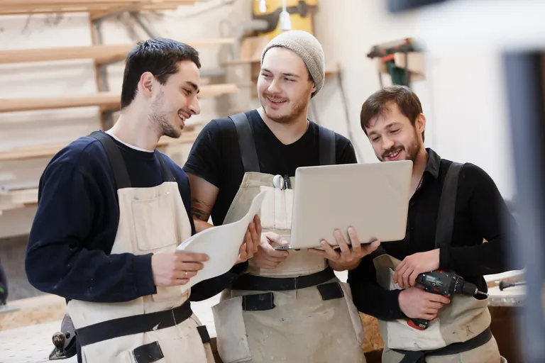 Mehrere junge Handwerker am T&uuml;fteln