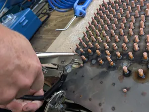 Heinz Soyer kontrolliert eine Platte voller Testschwei&szlig;ungen. Auch mit roher Gewalt per Hammer oder Zange lassen sich die Bolzen h&ouml;chstens &shy;verbiegen, nicht aber von der Unterlage trennen.