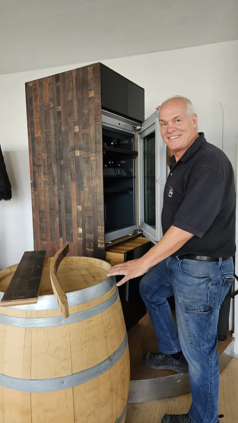 Schreinermeister Egon Kupferschmid mit Weinfass und Weinschrank
