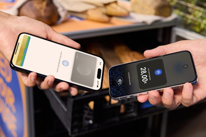 Zwei Personen halten ihre Smartphones aneinander, um eine kontaklose Zahlung durchzuführen