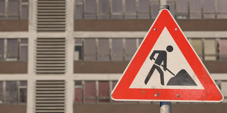 Schild Bauarbeiten, im Hintergrund alte Fassade