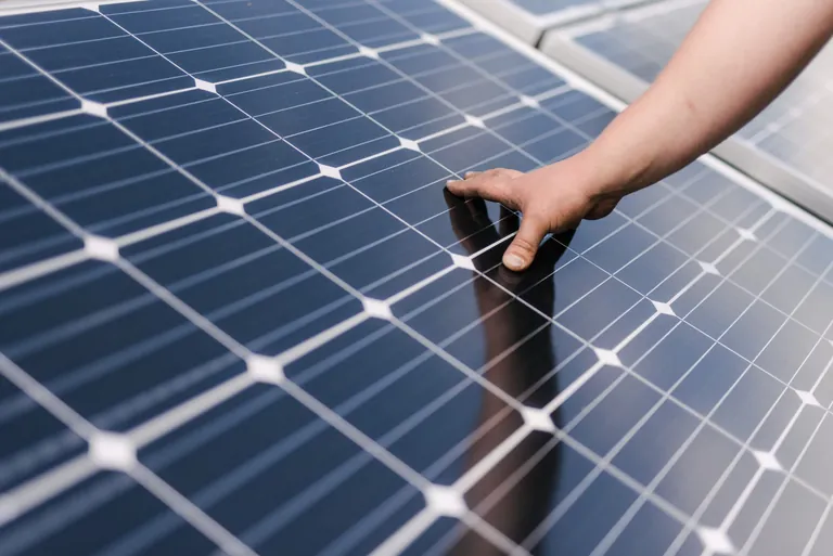 Die Hand eines Monteurs auf einer PV-Anlage